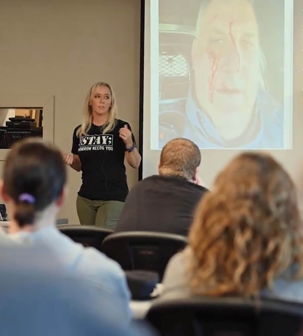 Christi presenting in front of a crowd